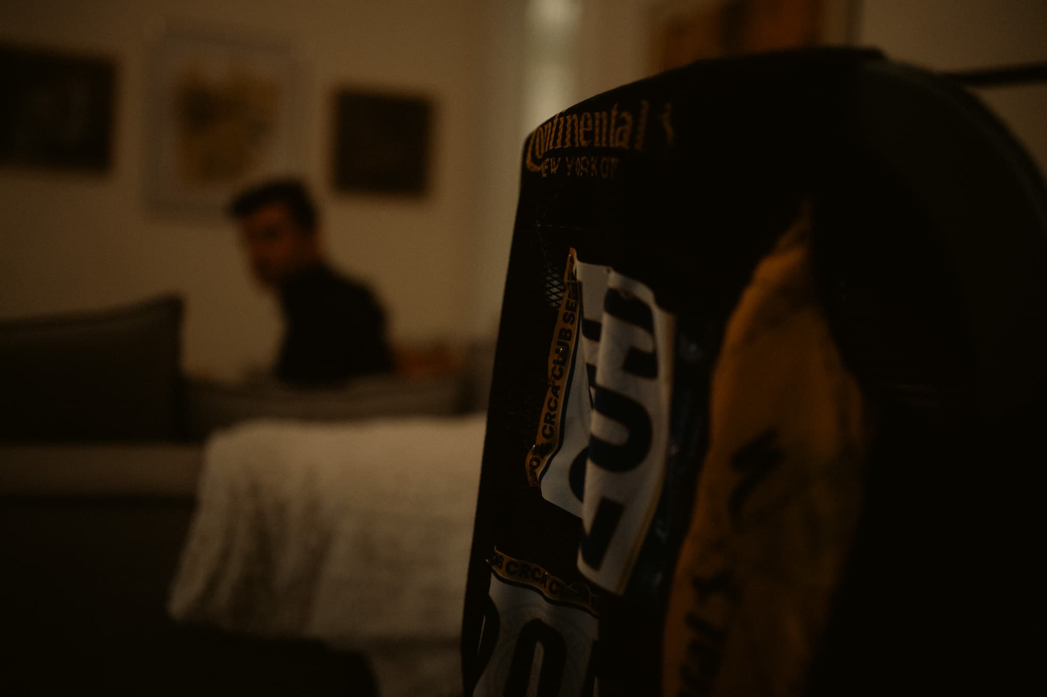 Racing jersey in foreground, rider sitting on bed in background