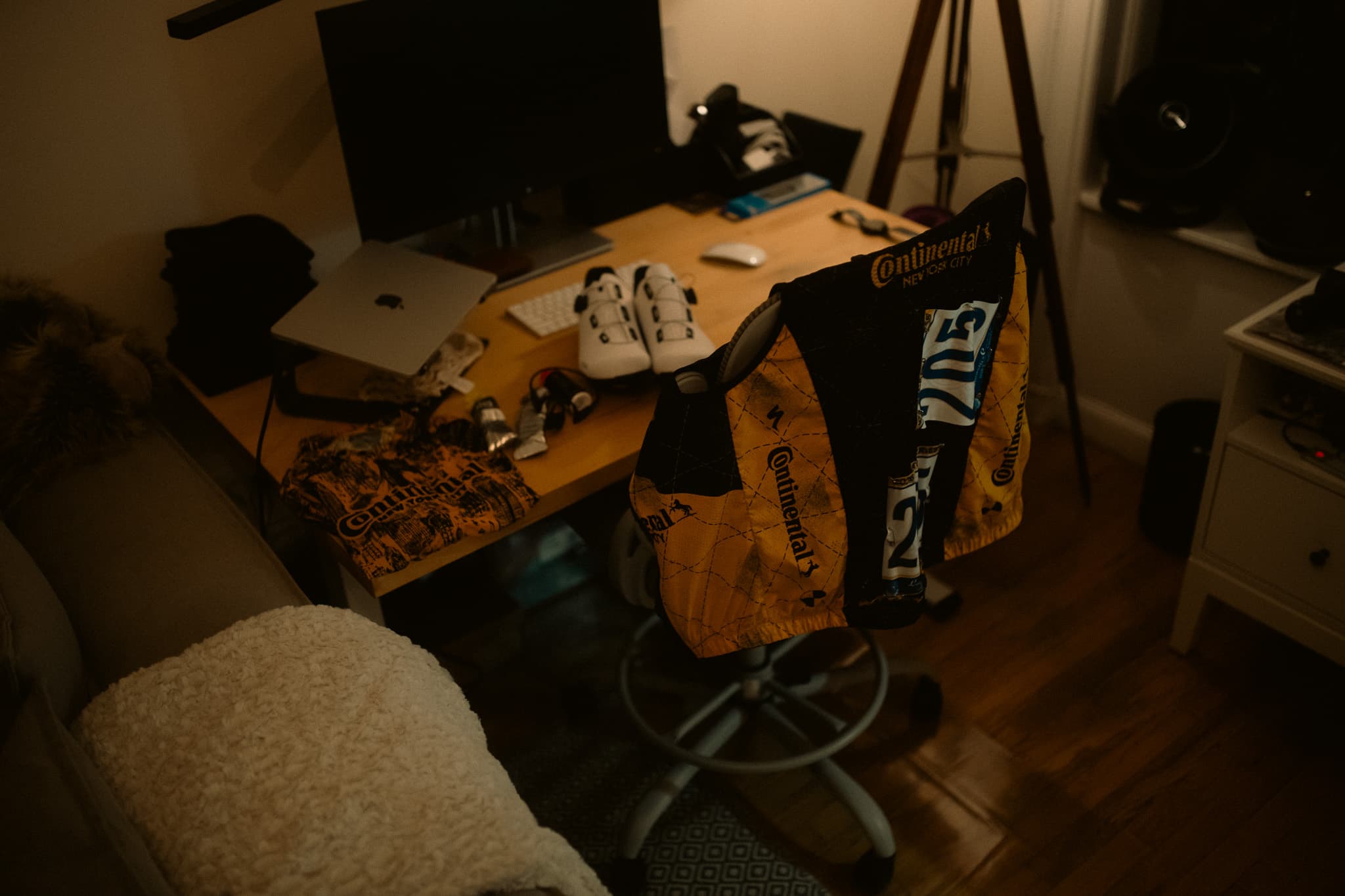 Overhead view of desk with cycling kit draped over chair and shoes
