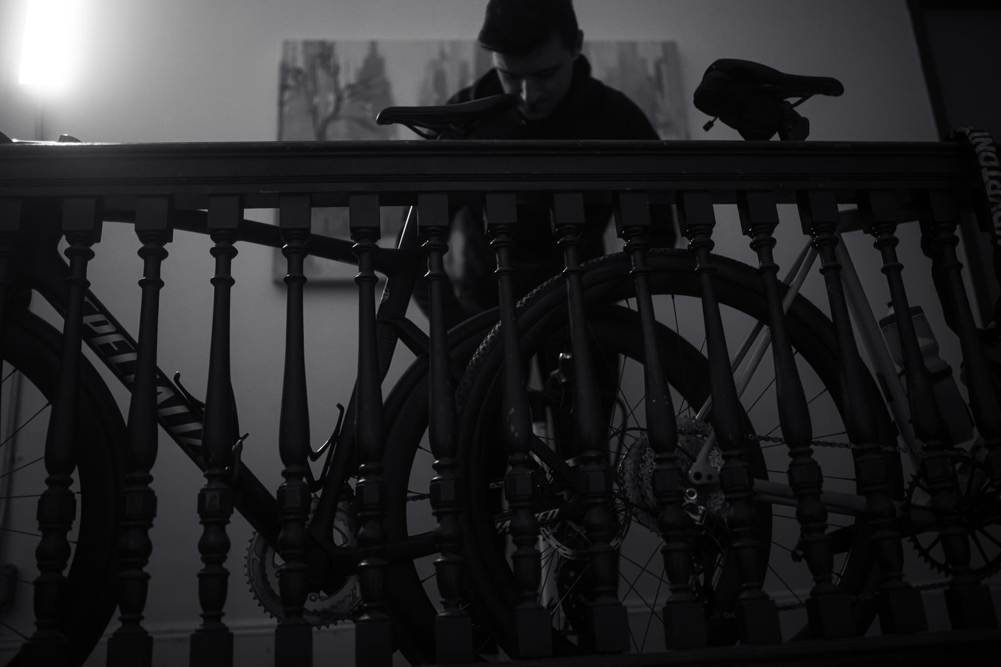 Bike leaning against stairwell banister, rider behind it