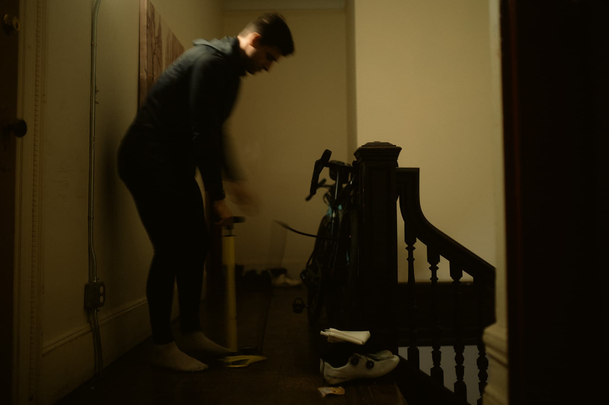Rider pumping tires in the hallway, bike on the banister