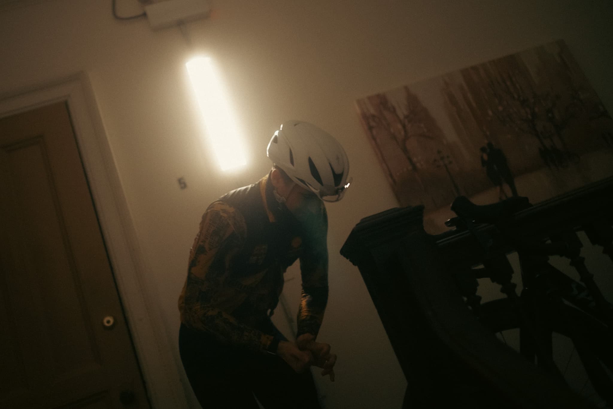 Rider in helmet bending over bike at top of stairs